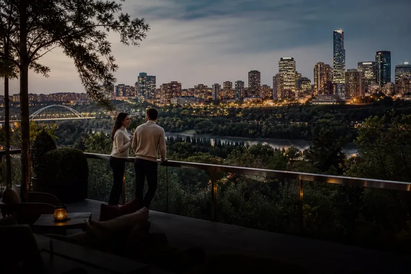 A couple overlooking Edmonton's illuminated river valley skyline
